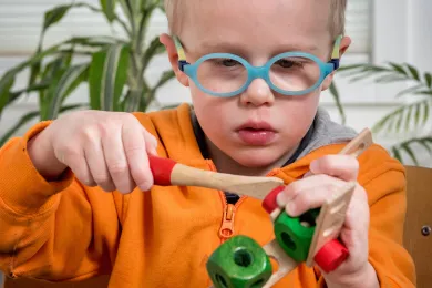 Ein Kind baut ein Spielzeug aus Holz