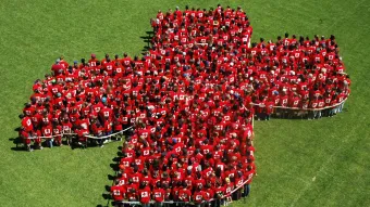 Eine Menschengruppe in Kreuzform