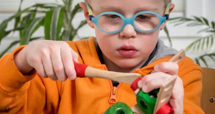 Ein Kind baut ein Spielzeug aus Holz