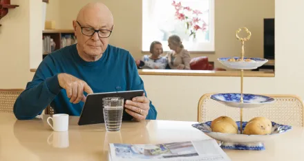 Mann mit Tablet am Küchentisch